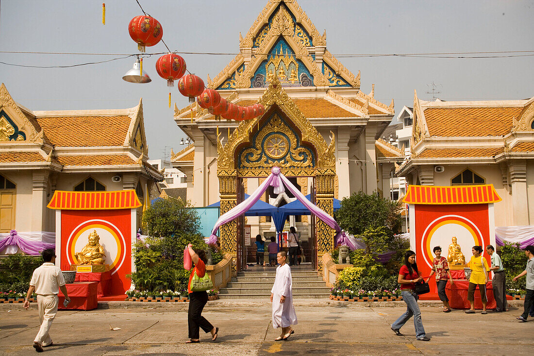 People visiting Wat Suthat, decorated for the Chinese New Year, Bangkok, Thailand