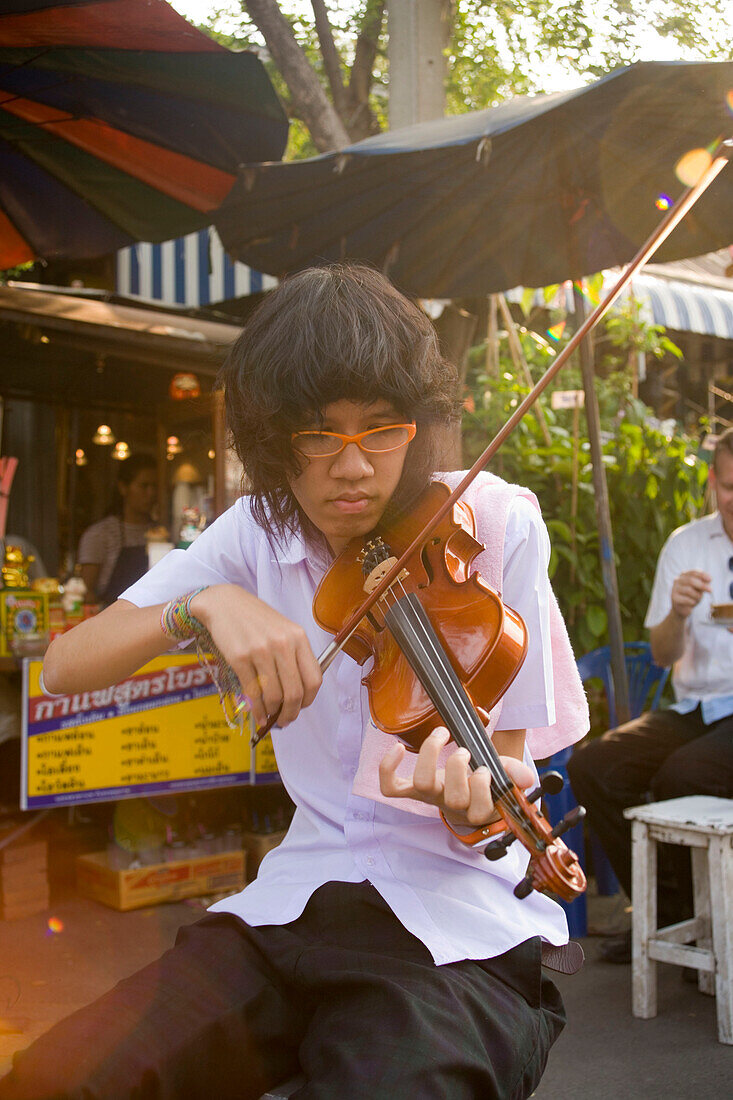 Young woman playing the violin at Suan Chatuchak Weekend Market, Bangkok, Thailand