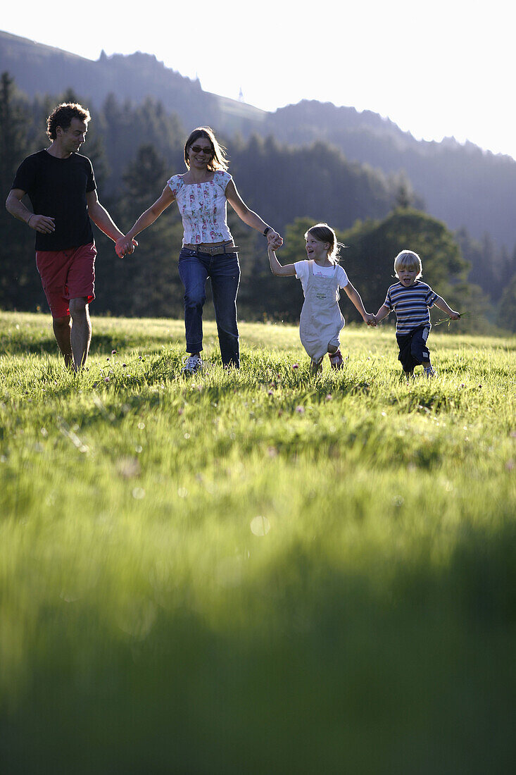 Familie läuft über Wiese