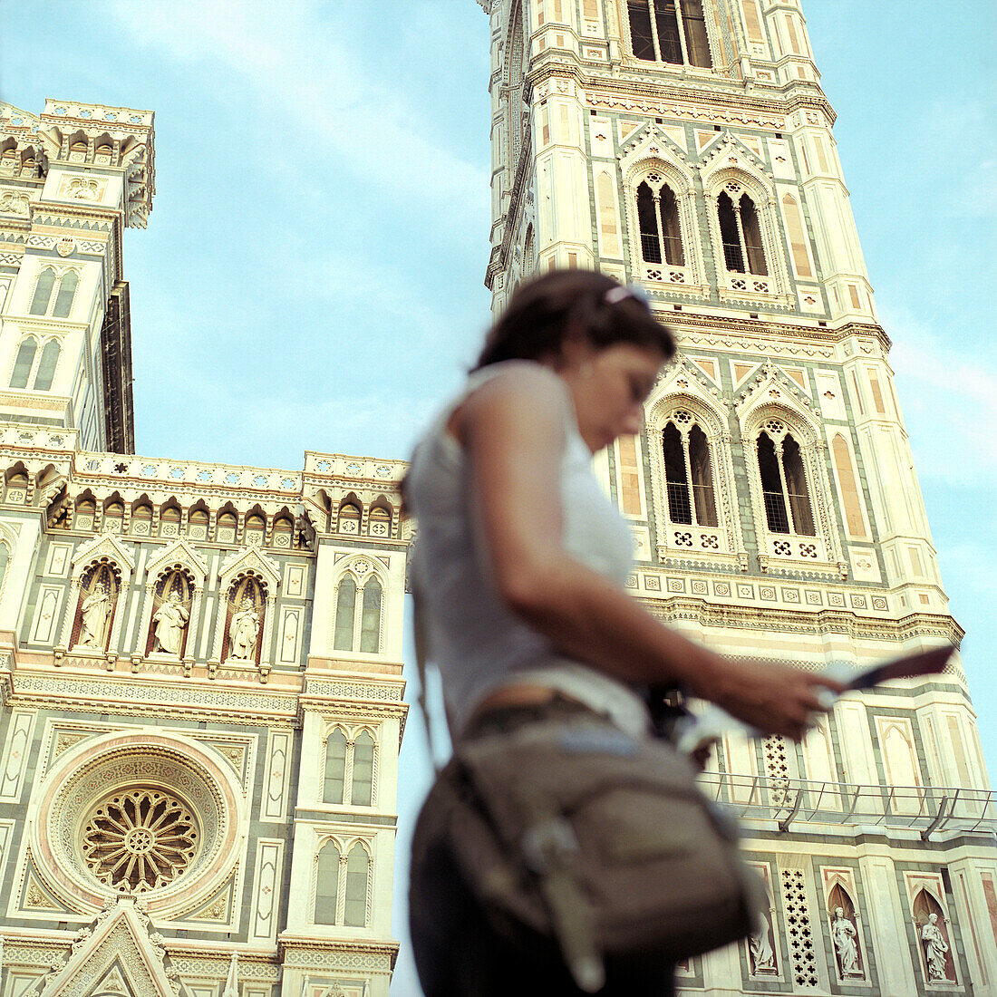 Young female tourist in front of Cathedral reading map, Florence, Tuscany, Italy