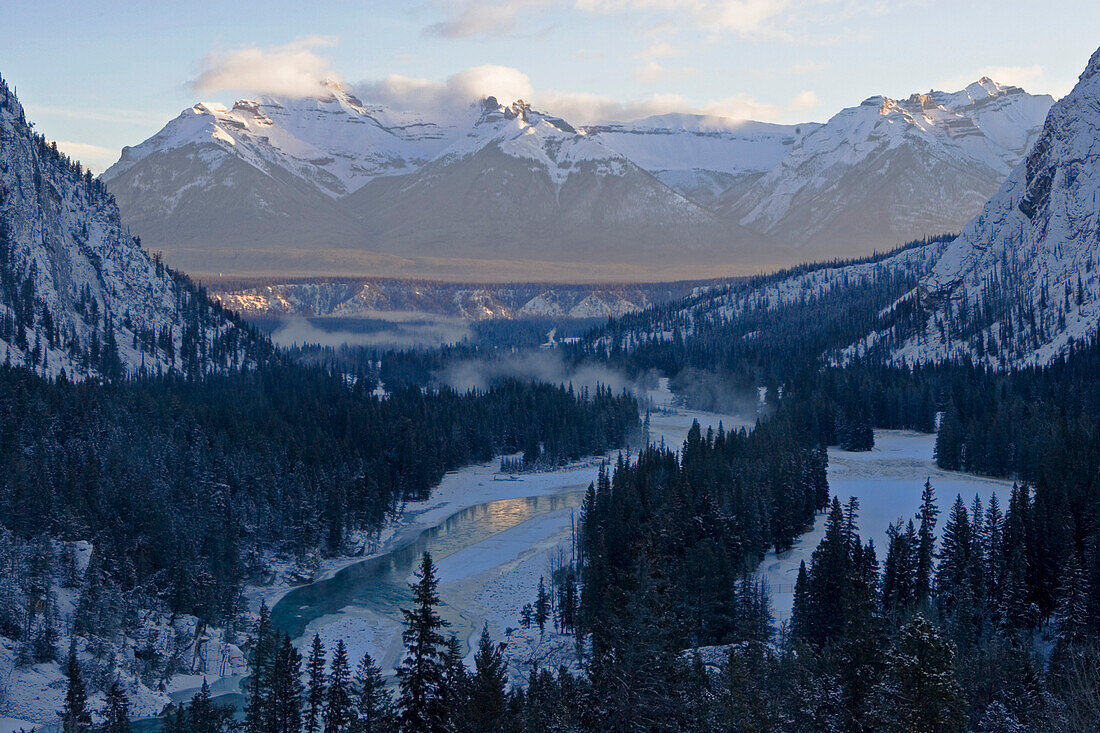 Ein Fluss fliesst durch eine winterliche Berglandschaft. Aussicht aus dem Banff Fairmont Springs Hotel. Banff Bow River Valley, Rocky Mountains, Alberta, Kanada, Nord Amerika