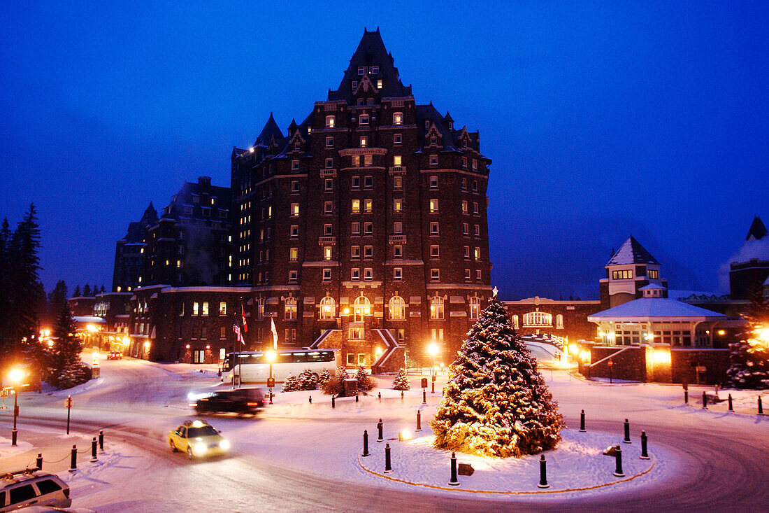 A big house, building and a christmas tree in the winter. Evening, Banff Fairmont Springs Hotel, Rocky Mountains, Alberta, Canada, North Amerika