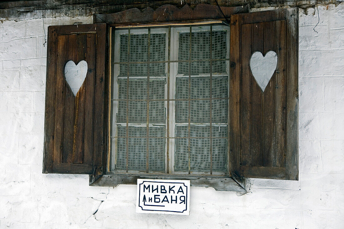 Fenster, Fensterläden und Herzchen. Das Schild weist in Richtung Dusche und Bad. Bulgarische Hüttenromantik. Demjanica Hütte, Pirin Gebirge. Bulgarien, Europa