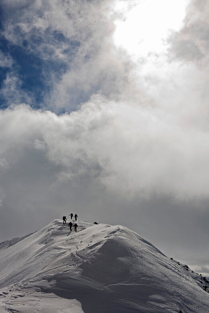 A group of skitourists, mountaineers climb, hike to the top of Malka Todorka and Todorin Vrah, a storm approaches, Pirin Mountains, Bulgaria, Europe
