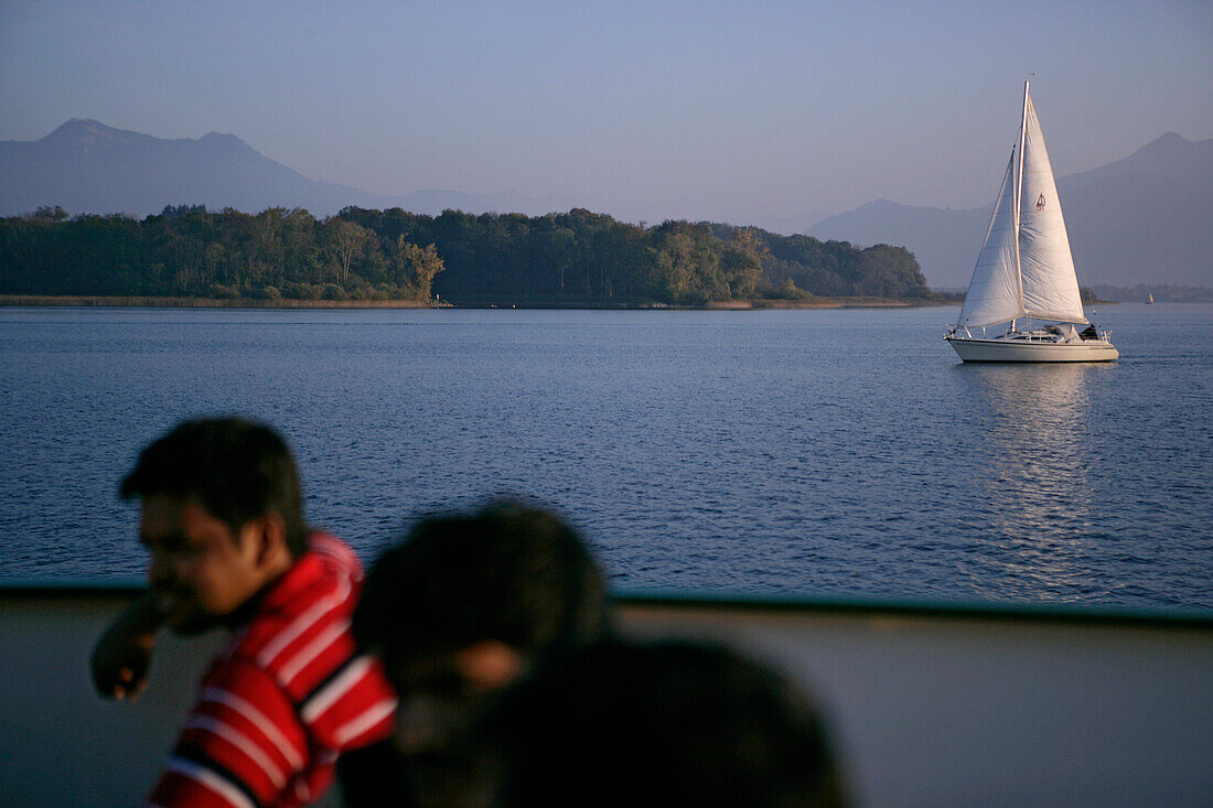 Passengers on a boat on Lake Chiemsee, Kampenwand in the background, Bavaria, Germany