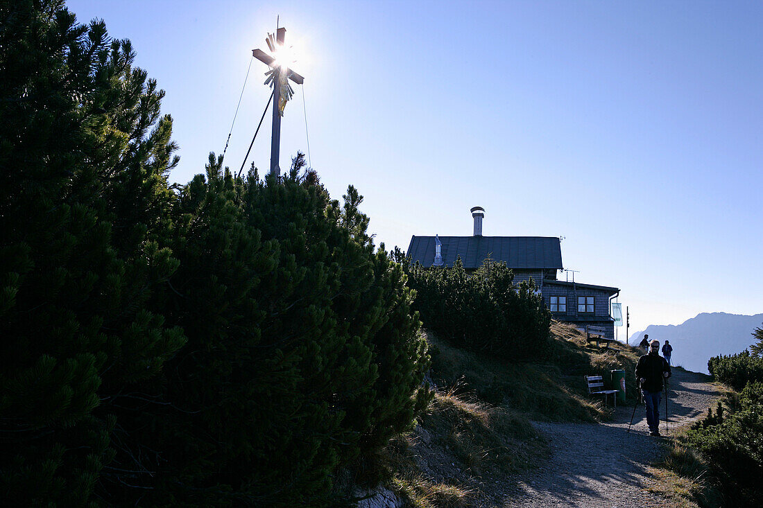 Hikers at the summit of the Wank with Wankhaus and cross, Wank, Bavaria, Germany