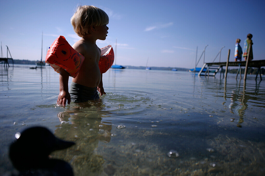 Junge mit Spielzeug Ente, im Wasser, Wörthsee, Bayern, Deutschland