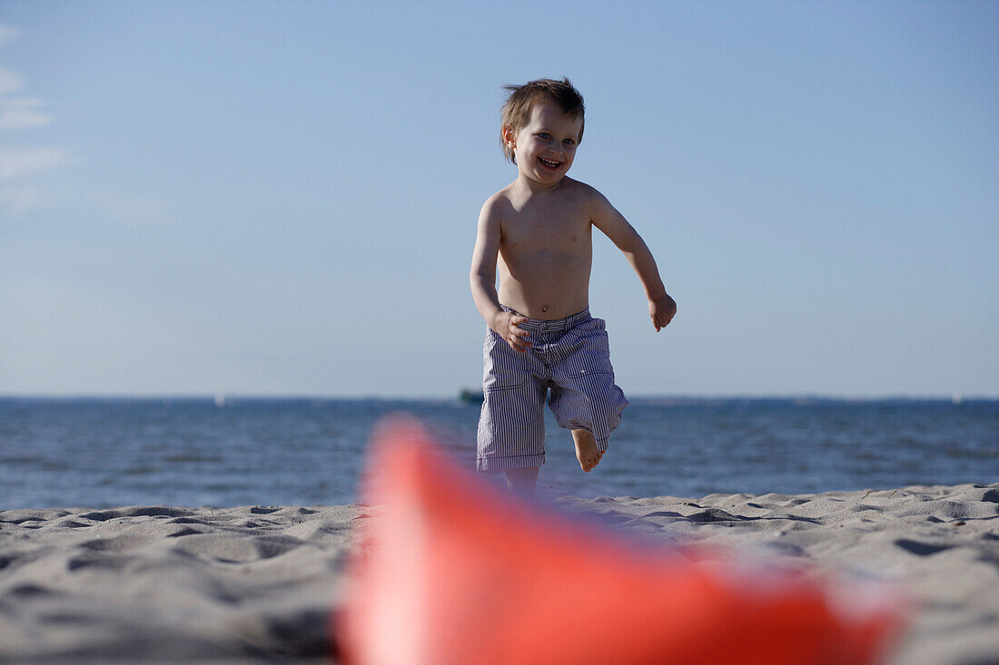 Boy running over sandy beach, Baltic Sea, Travemuende Bay, Schleswig-Holstein, Germany