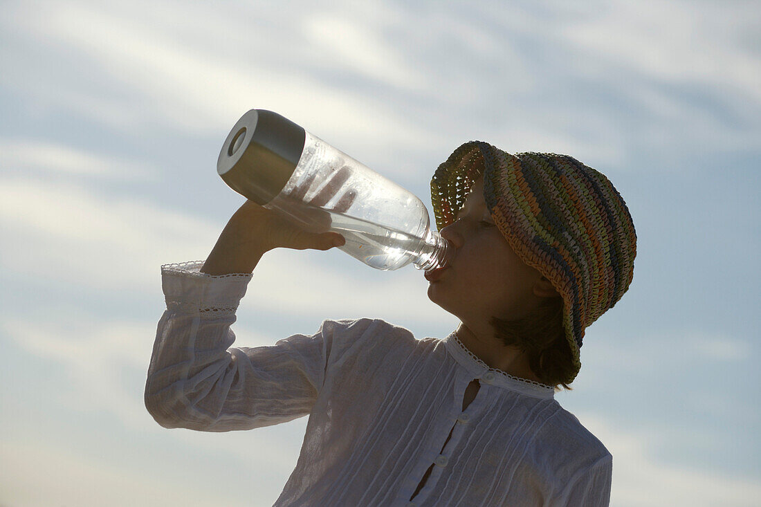 Girl drinking a bottle of water, Travemuende Bay, Schleswig-Holstein, Germany