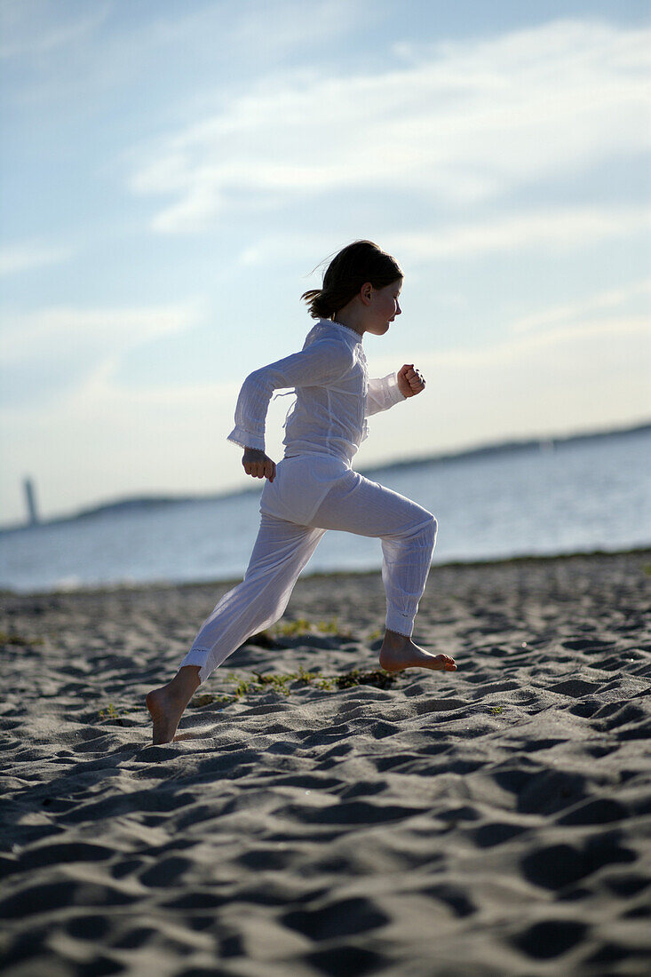 Mädchen rennt über den Ostseestrand, Travemünder Bucht, Schleswig-Holstein, Deutschland