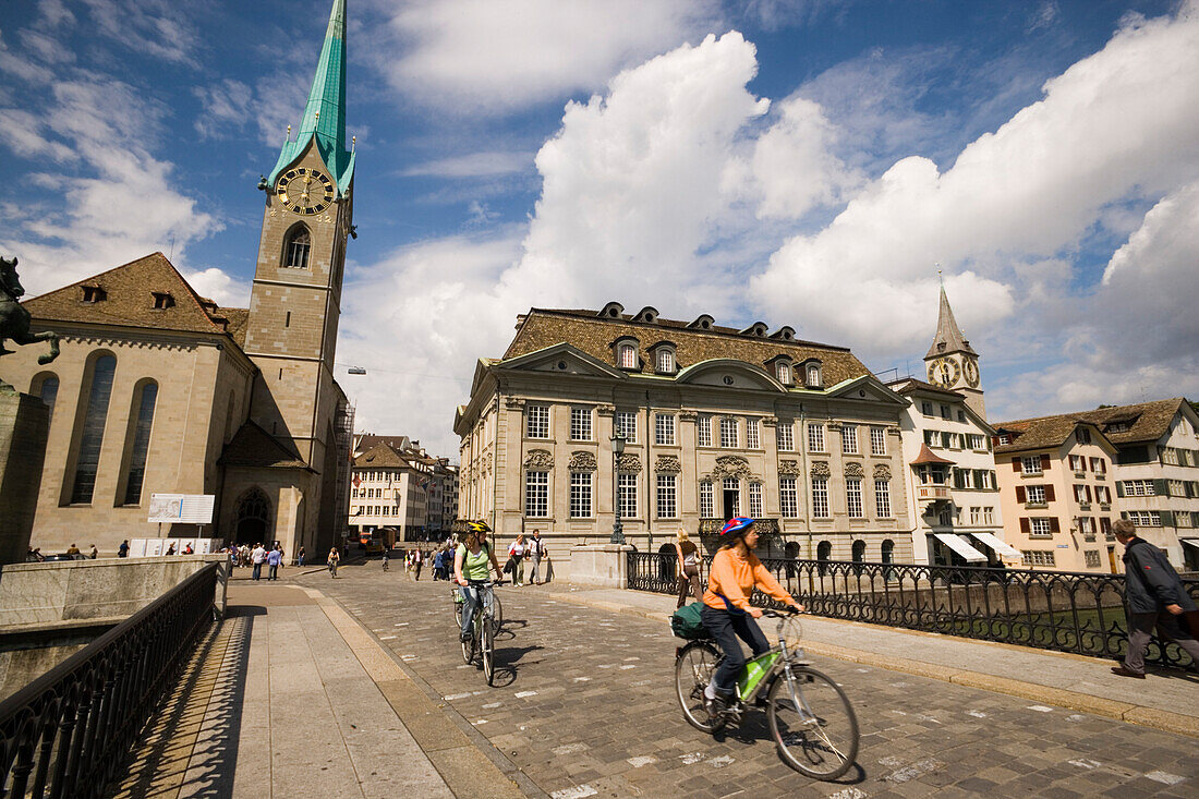 Cyclists passing Münster Bridge, Fraumünster and Helmhaus in background, Zurich, Canton Zurich, Switzerland