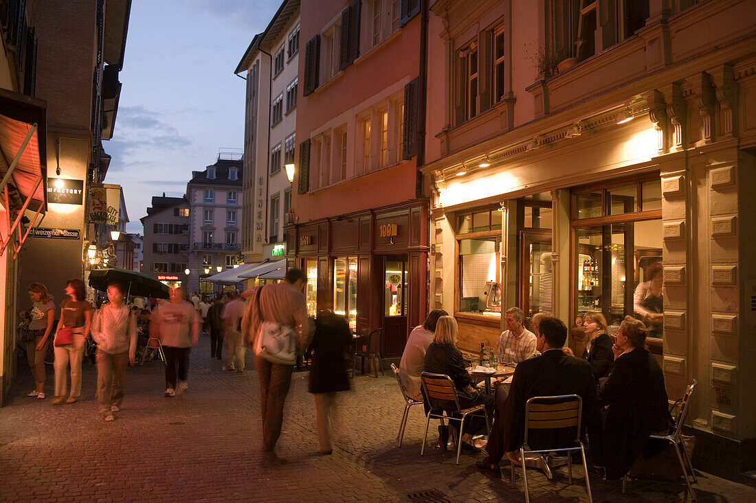 People sitting in a small pavement cafe in the late evening near Hirschenplatz, Niederdorfstrasse, Zurich, Canton Zurich, Switzerland