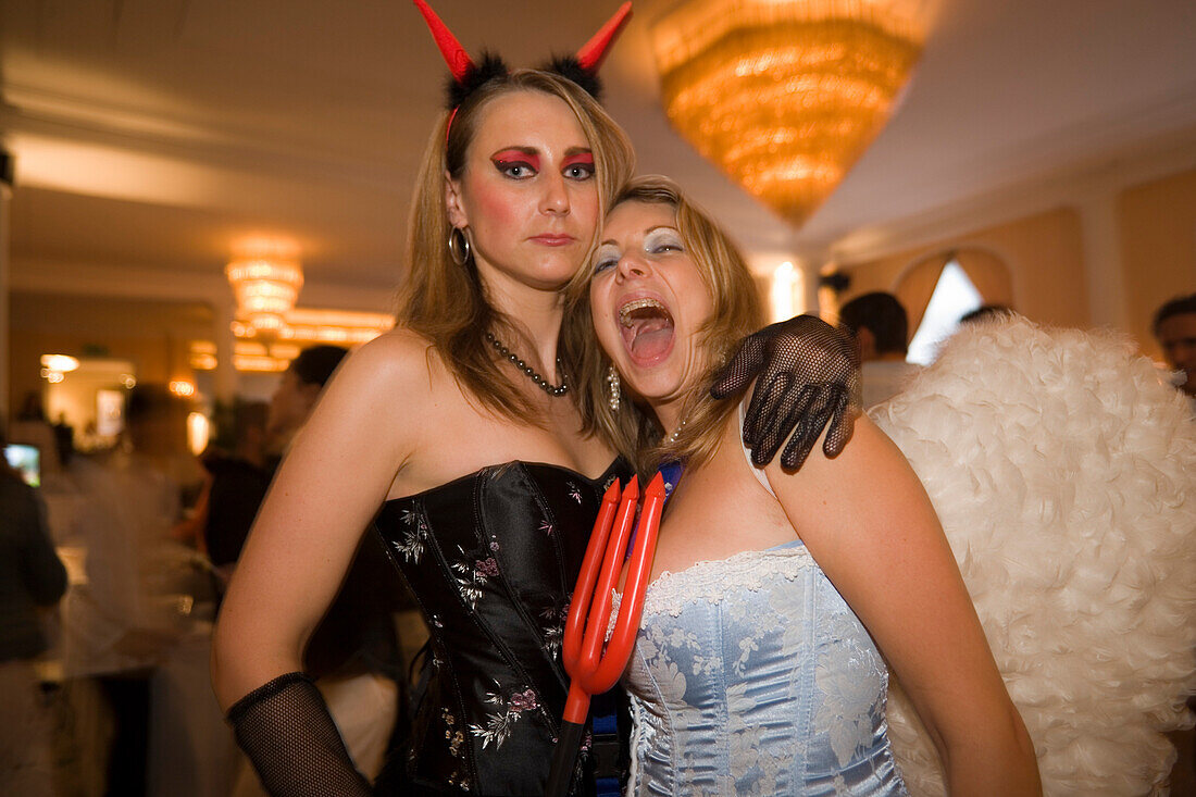 Portrait of two girls dressed up as angel and devil in the louge of the Baur au Lac Hotel, After Party of the Street Parade (the most attended technoparade in Europe), Zurich, Canton Zurich, Switzerland