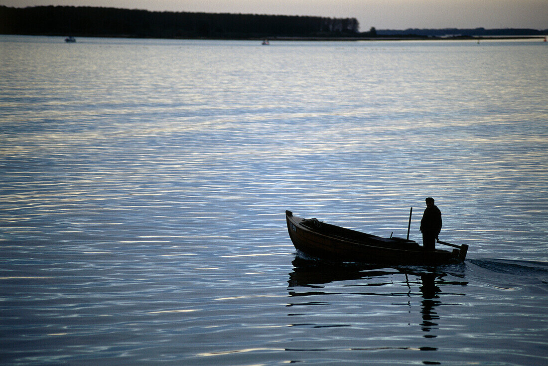 Fischer am Abend in seinem Boot, auf Bodden Trog, an Insel Hiddensee, Mecklenburg-Vorpommern, Deutschland