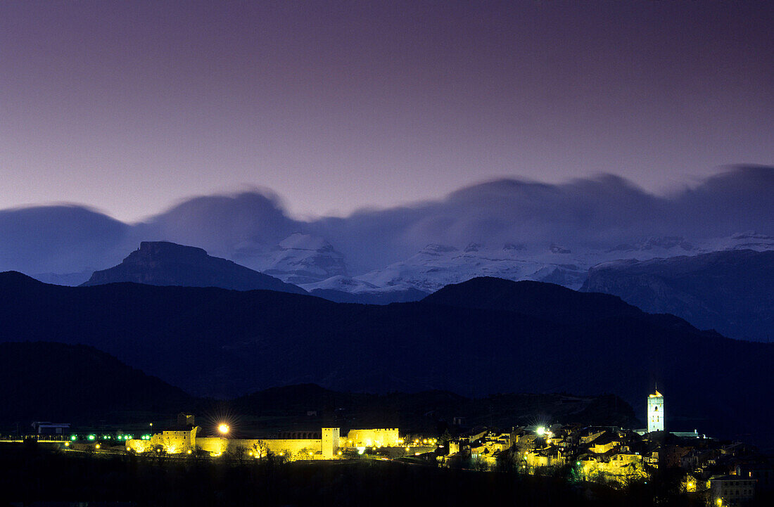 Altstadt von Anisa mit beleuchteter Burg und der Kulisse der schneebedeckten Pyrenäen, Nachtaufnahme, Pyrenäen, Spanien