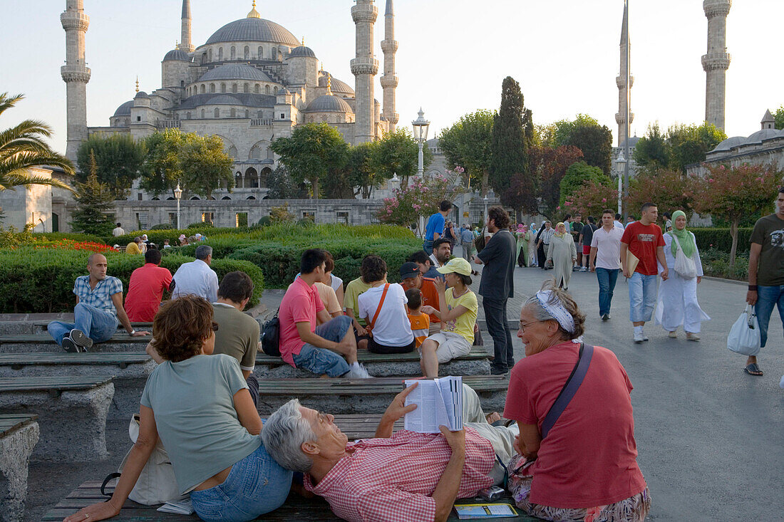 Tourist Reading Lonely Planet Guidebook near Sultan Ahmet Blue Mosque, Sultan Ahmet, Istanbul, Turkey