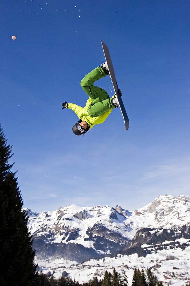 Ein junger Mann, ein Snowboarder springt kopfüber, im Funpark Snowland, Wildhaus, Toggenburg, Ostschweiz, St, Gallen, Schweiz, Alpen, Europa