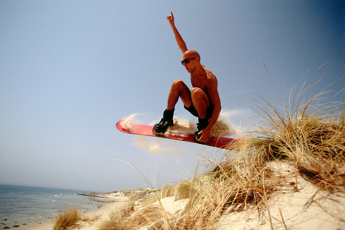 Man sandboarding on sand dunes, Tarifa, Andalusia, Spain, Europe
