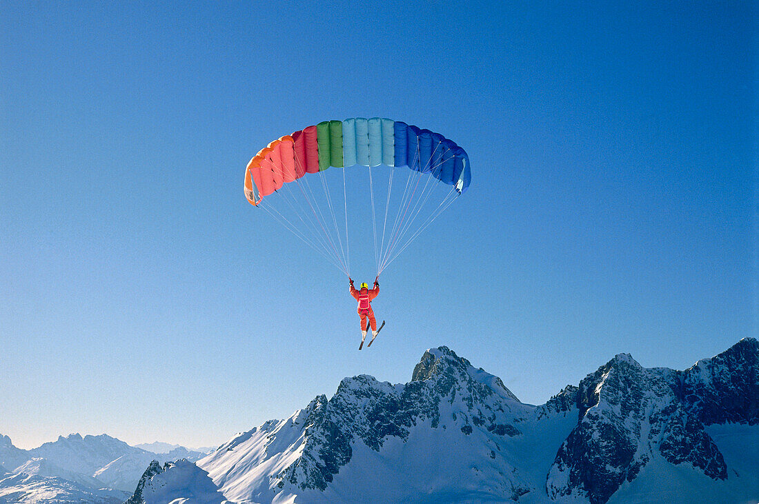 Paraglider above snow covered mountains