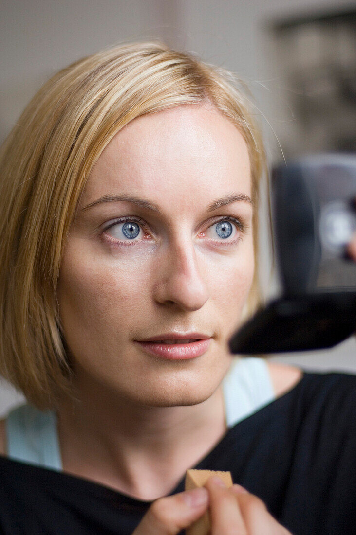 Young woman applying make-up