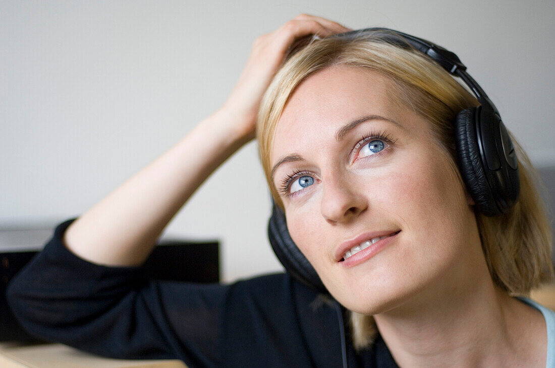 Young woman listening to music about earphones