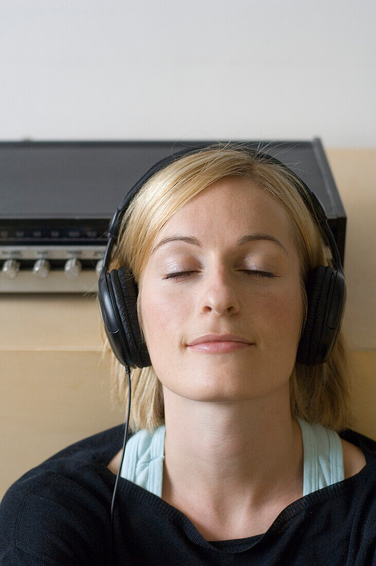 Young woman listening to music about earphones