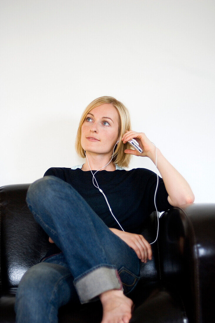 Young woman listening to music about earphones