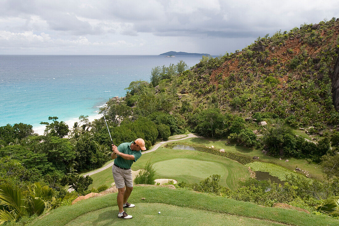 Golfer beim Abschlag an Loch 15, Golfplatz, Lemuria Resort auf Praslin, Praslin Island, Seychellen