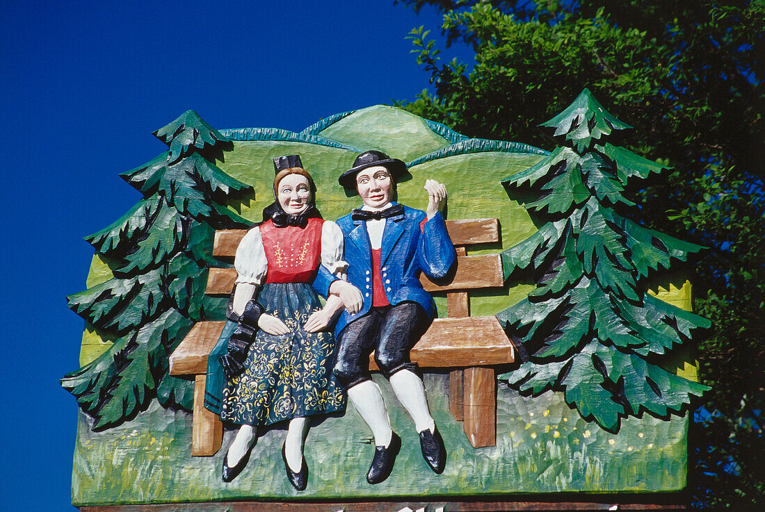 Wooden sign, picture of couple with traditional clothes, Black Forest, Baden-Wuerttemberg, Germany