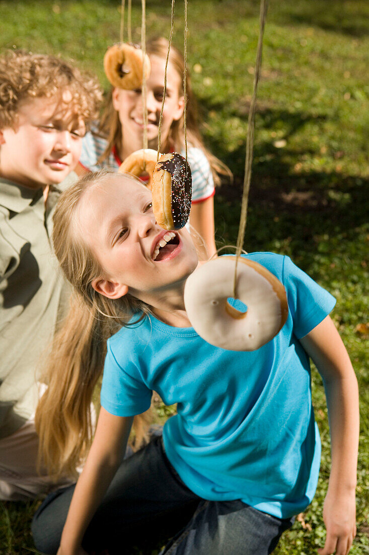 Children playing donut catching, children's birthday party