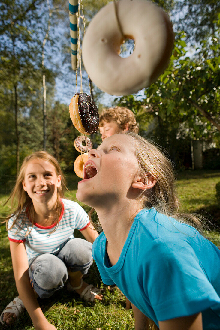 Mädchen spielen Donutschnappen, Kindergeburtstag