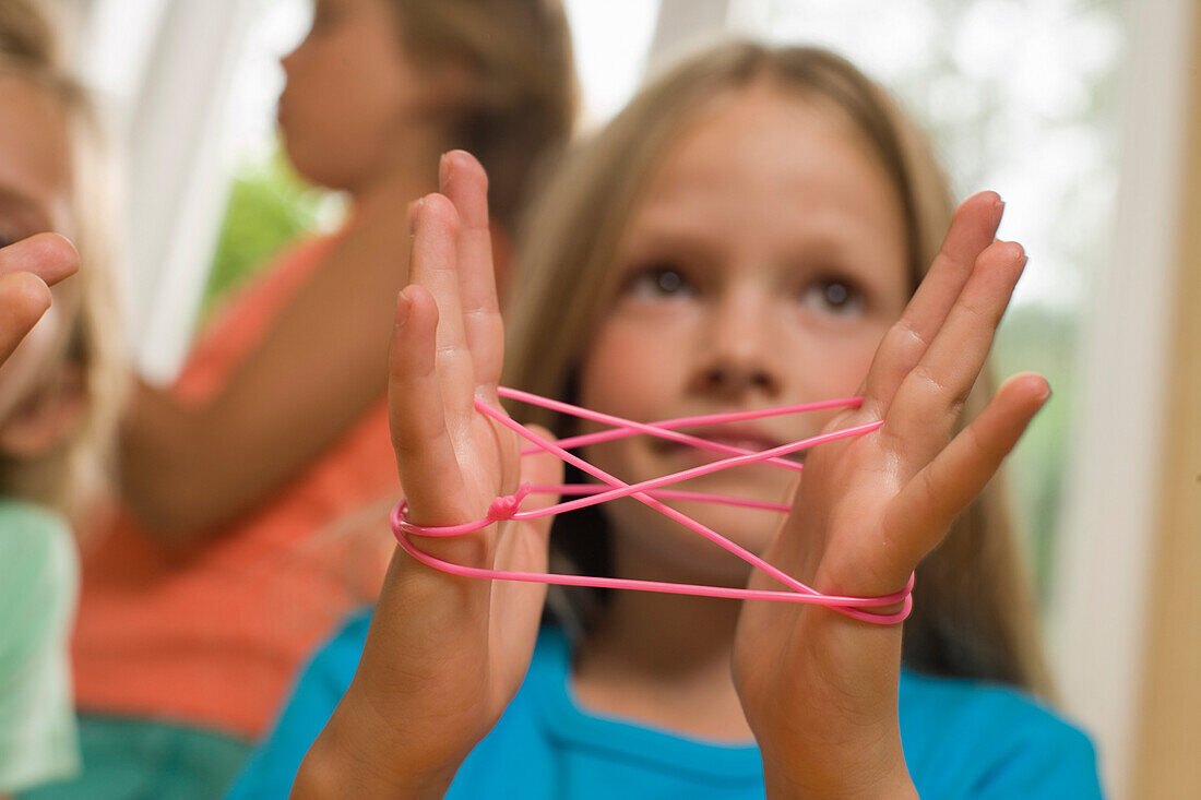 Mädchen spielt Fadenspiel, Kindergeburtstag