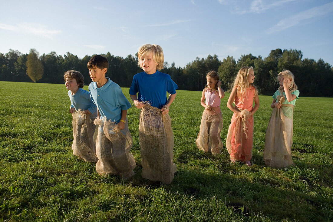 Gruppe Kinder beim Sackhüpfen, Kindergeburtstag