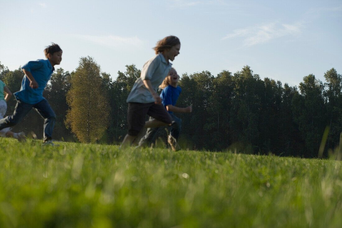 Two boys running over field, children's birthday party