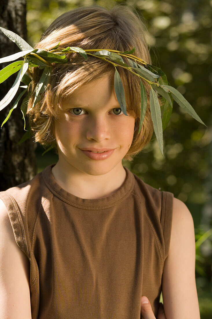 Junge mit einem Kranz aus Blättern auf dem Kopf, Portrait