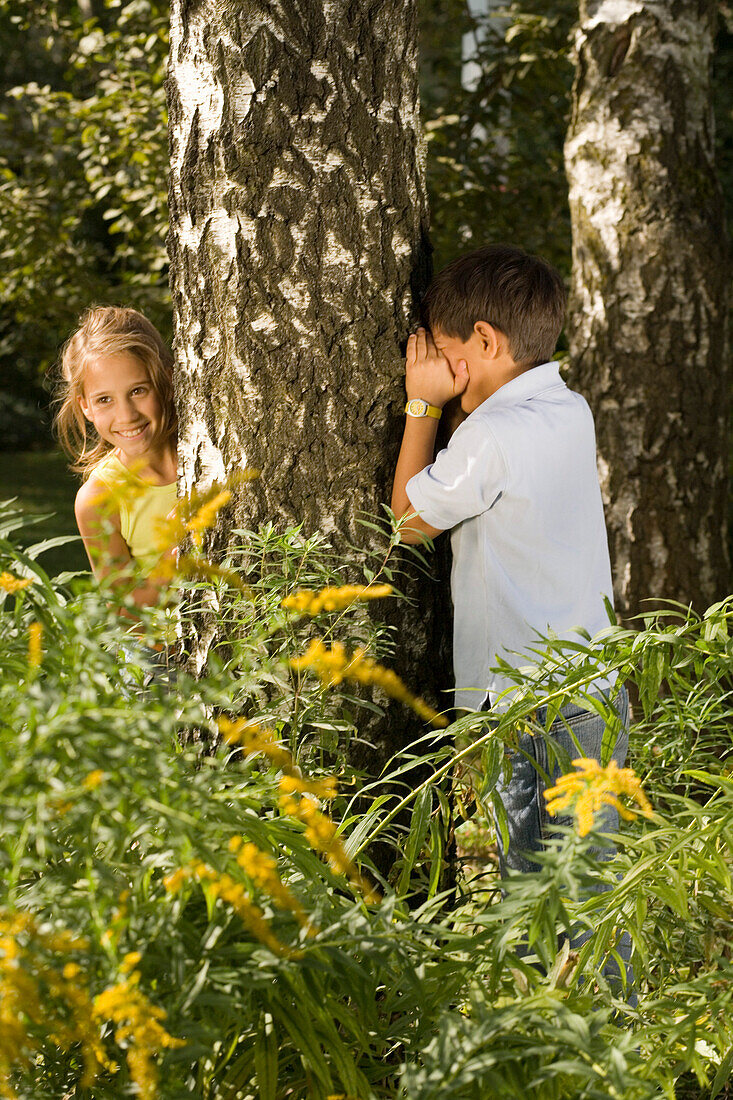 Mädchen und Junge spielen Verstecken, Kindergeburtstag