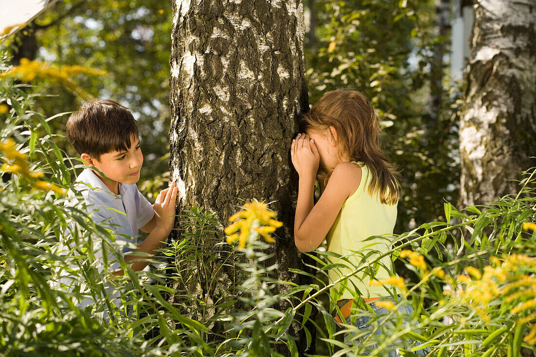 Mädchen und Junge spielen Verstecken, Kindergeburtstag