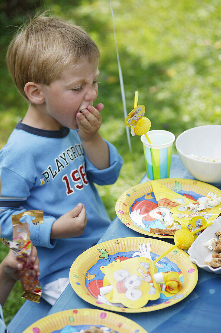 Young boy eating popcorn