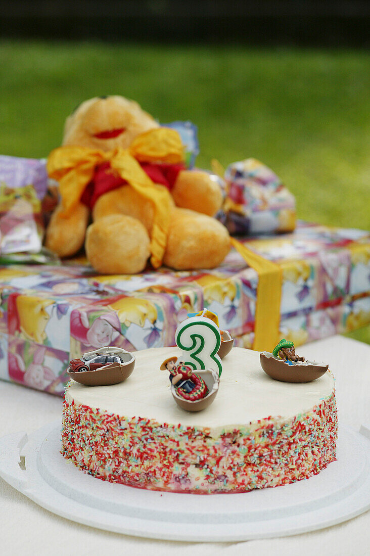 Birthday cake and presents on table
