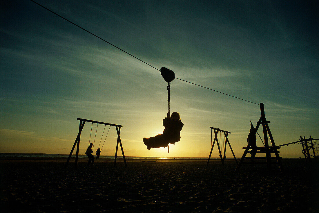 Children playing on playground at weat beach, island Norderney, East Friesland, Lower Saxony, Germany