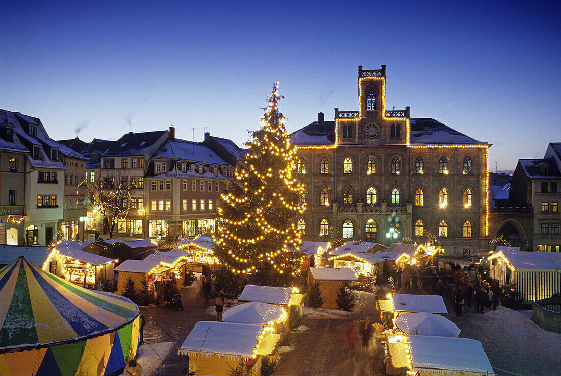 View over Christmas market to illuminated city hall, Weimar, Thuringia, Germany