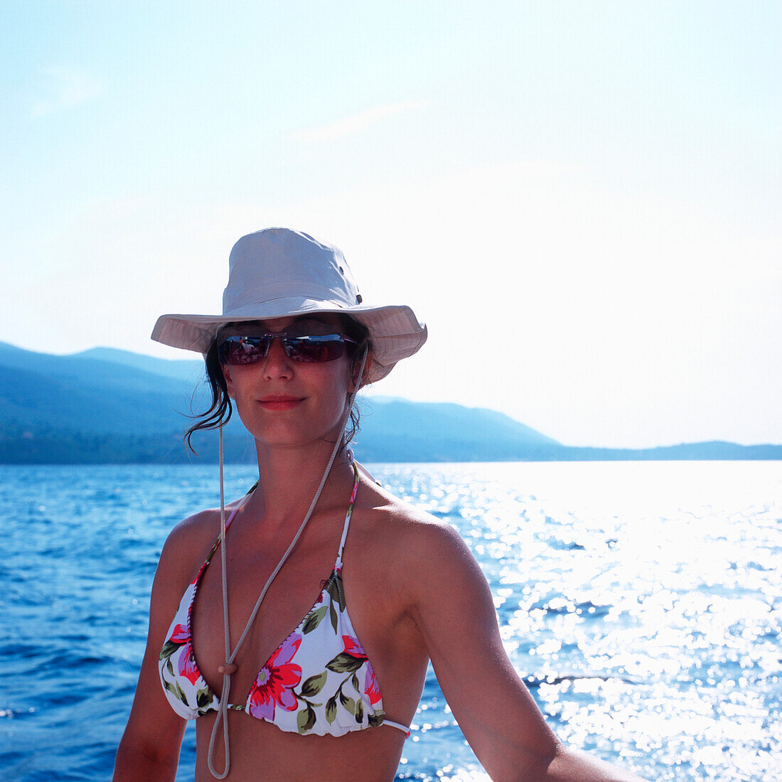 Frau in Bikini mit Sonnenbrille und Hut auf einem Segelboot, Dalmatien, Kroatien