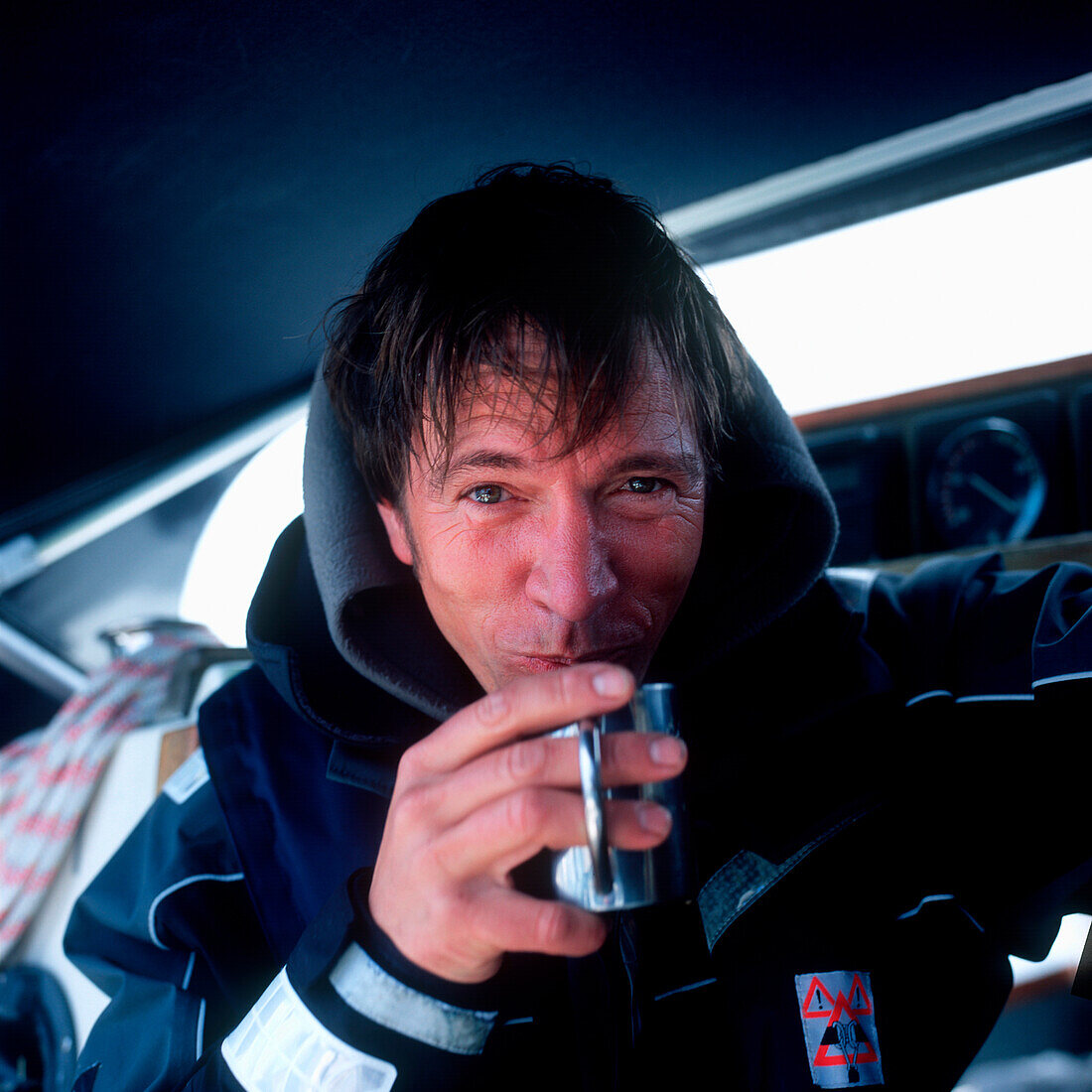 Mann auf einem Segelboot trinkt eine Tasse heißen Kaffee, Kieler Bucht zwischen Deutschland und Dänemark, Porträt