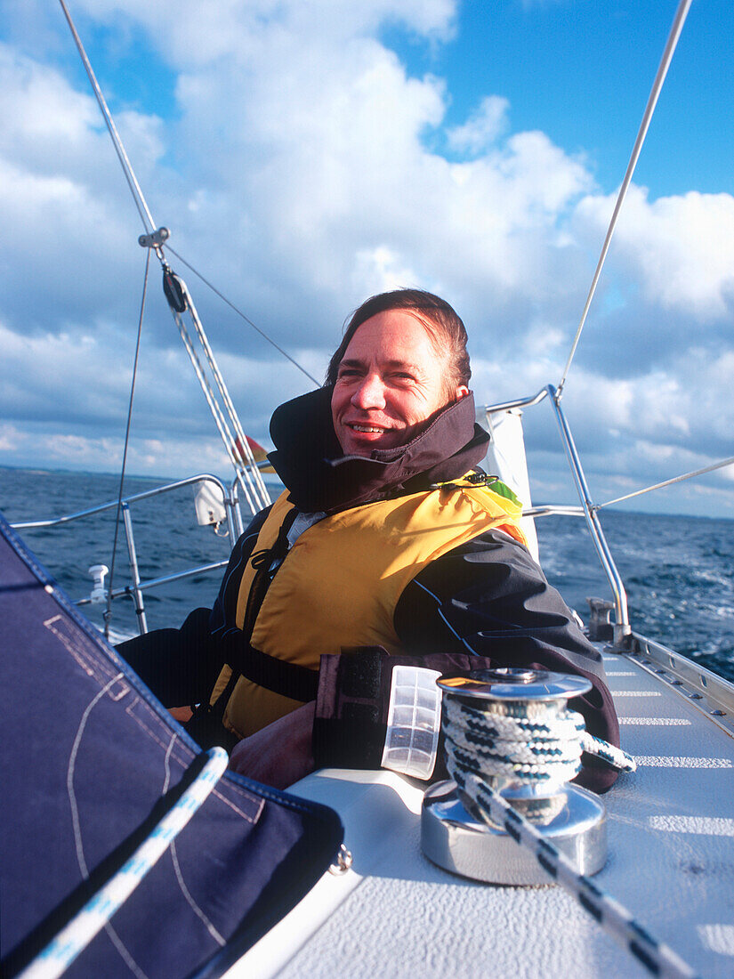 Man wearing lifejacket on sailboat, Bay of Kiel between Germany and Denmark