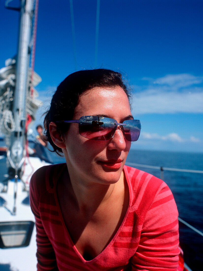 Frau mit Sonnenbrille auf einem Segelboot, Kieler Bucht zwischen Deutschland und Dänemark