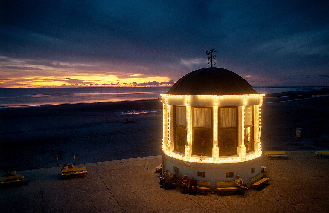 An illuminated beach pavilion at dusk, Borkum Island, East Frisia, Lower Saxony, Germany