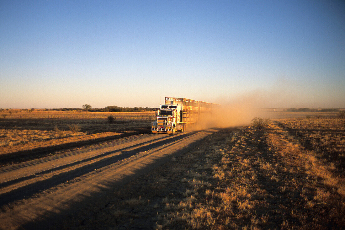 Ein Fernlaster unterwegs auf eine unbefestigte Landstraße, in der Nähe von Kynuna, Queensland, Australien