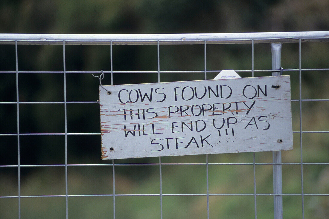 Militantes Warnschild gegen Kühe, in der Nähe von Strahan, Tasmanien, Australien