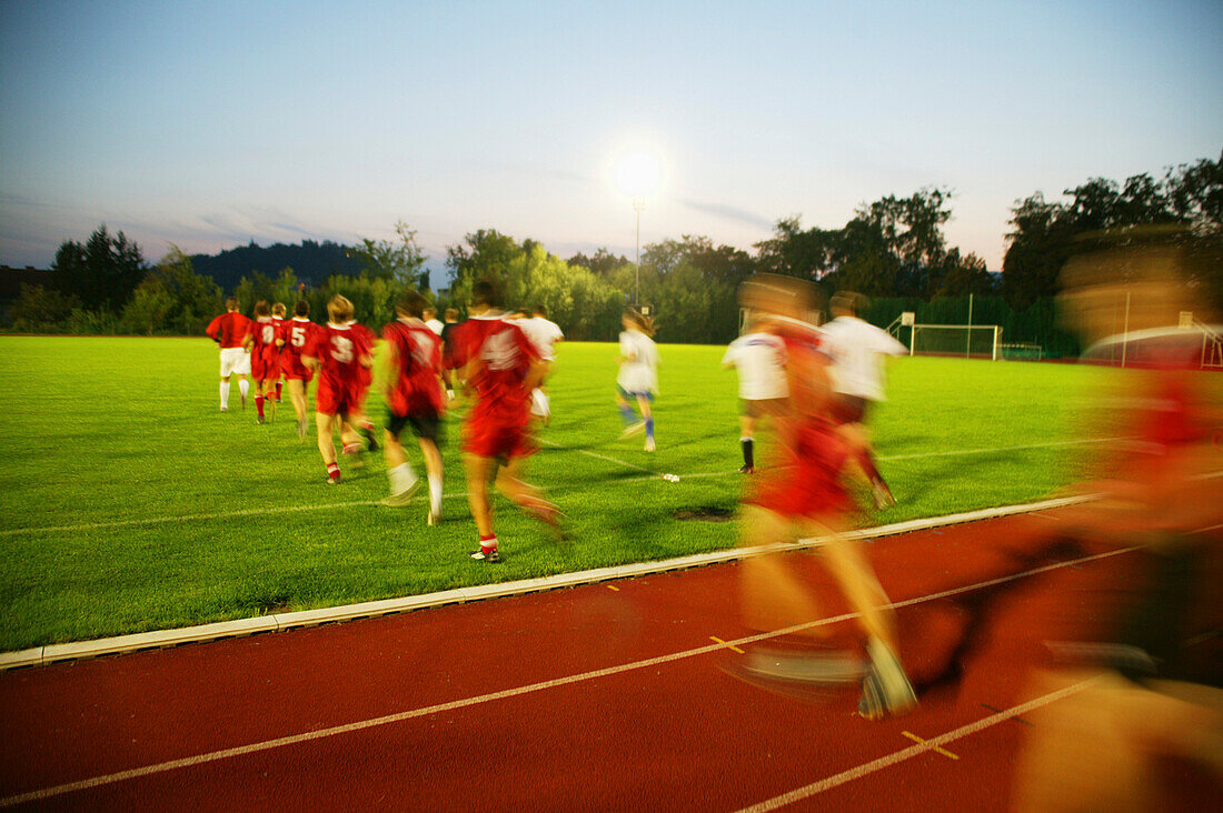 Soccer teams running on field