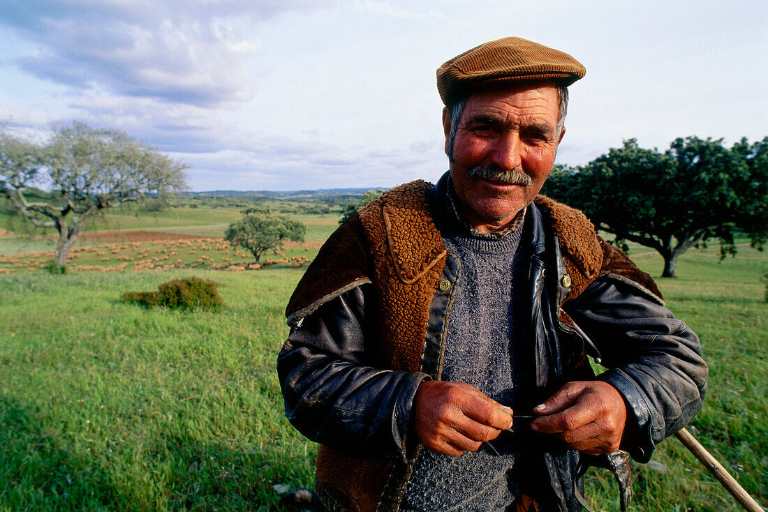 Schäfer in traditioneller Weste, Weideland mit Korkeichen nahe Odemira südlich von Alantejo, Portugal